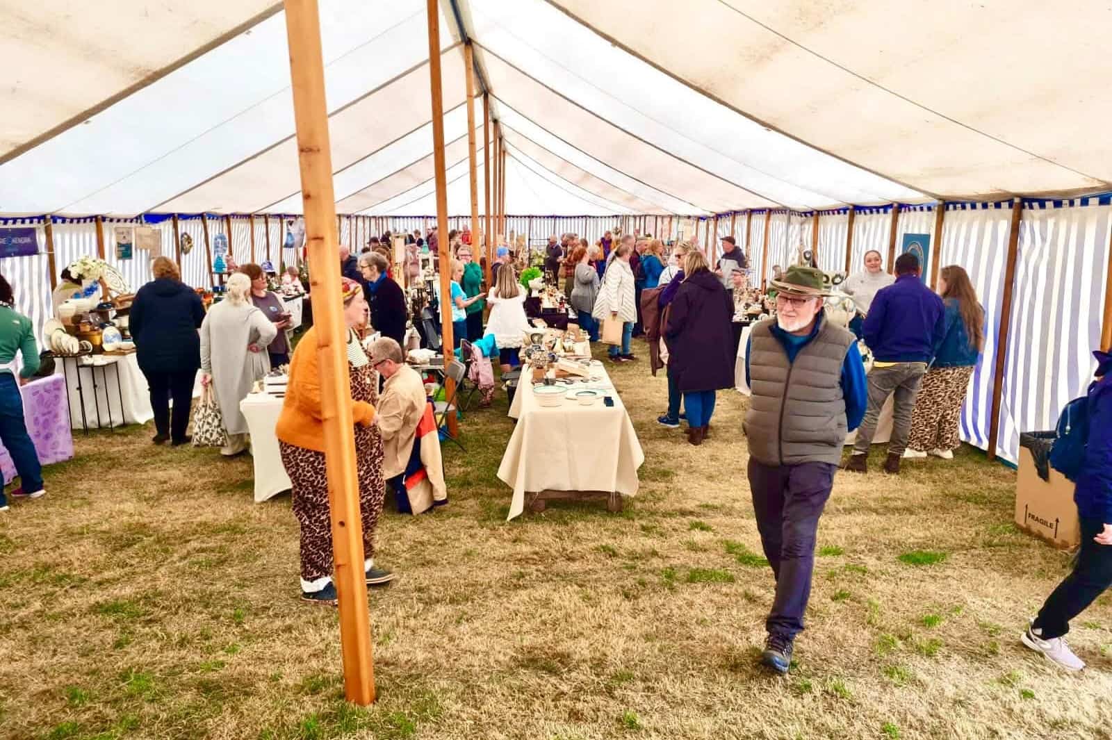 Visitors browsing pottery and ceramics stands inside the marquee at Fired and Inspired Pottery Festival 2026