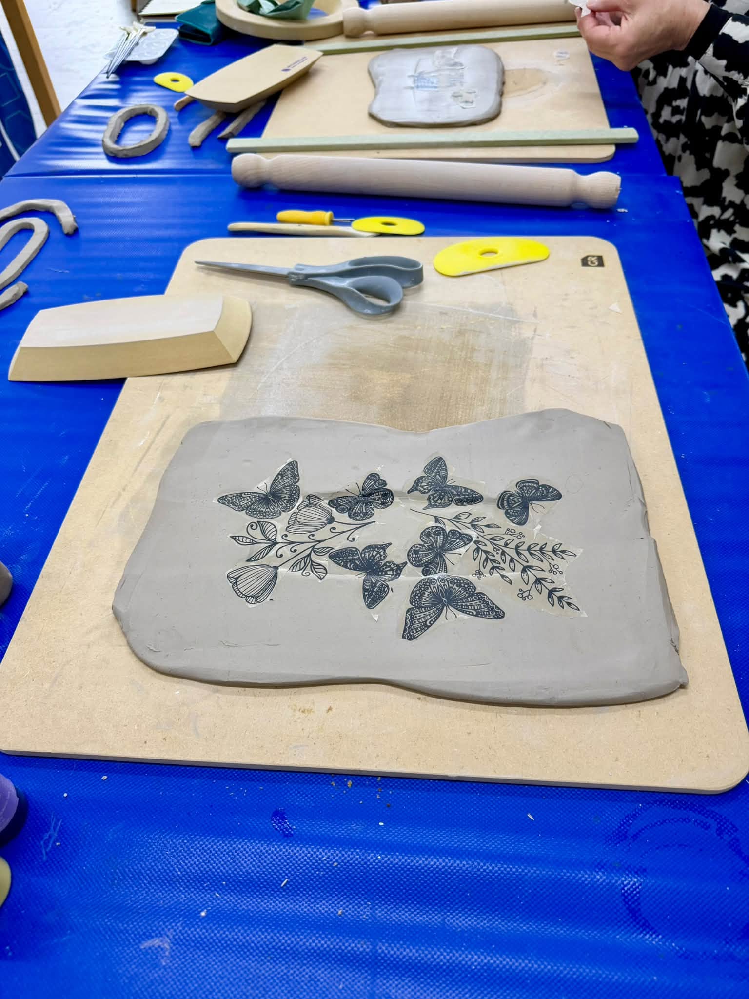 Finished clay slab decorated with detailed butterfly impressions during the GR Pottery Forms workshop