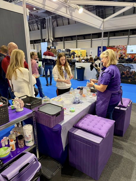 Cromartie team member demonstrating clay and craft materials to visitors at the 2025 show