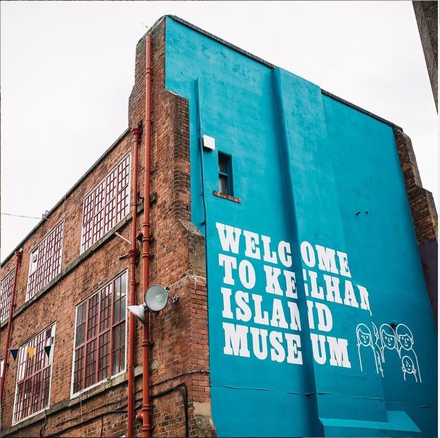 Welcome to Kelham Island Museum mural on the side of a red brick industrial building in Sheffield